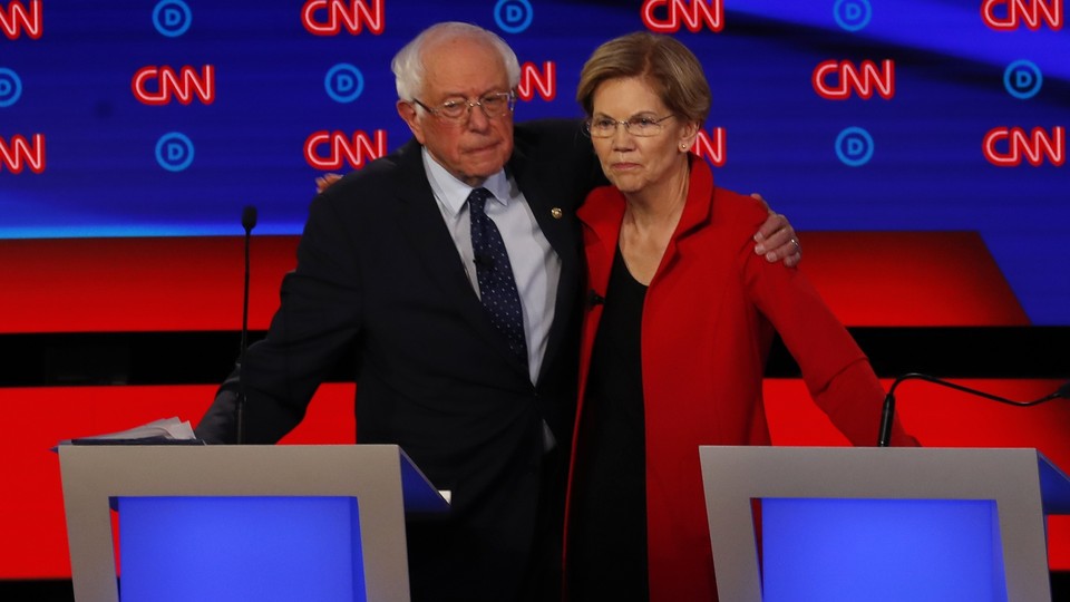 Bernie Sanders puts an arm around Elizabeth Warren.