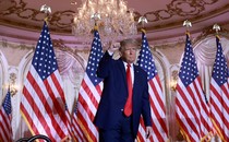 Donald trump raising in his fist in front of American flags