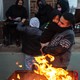 Texans stay warm by an open fire