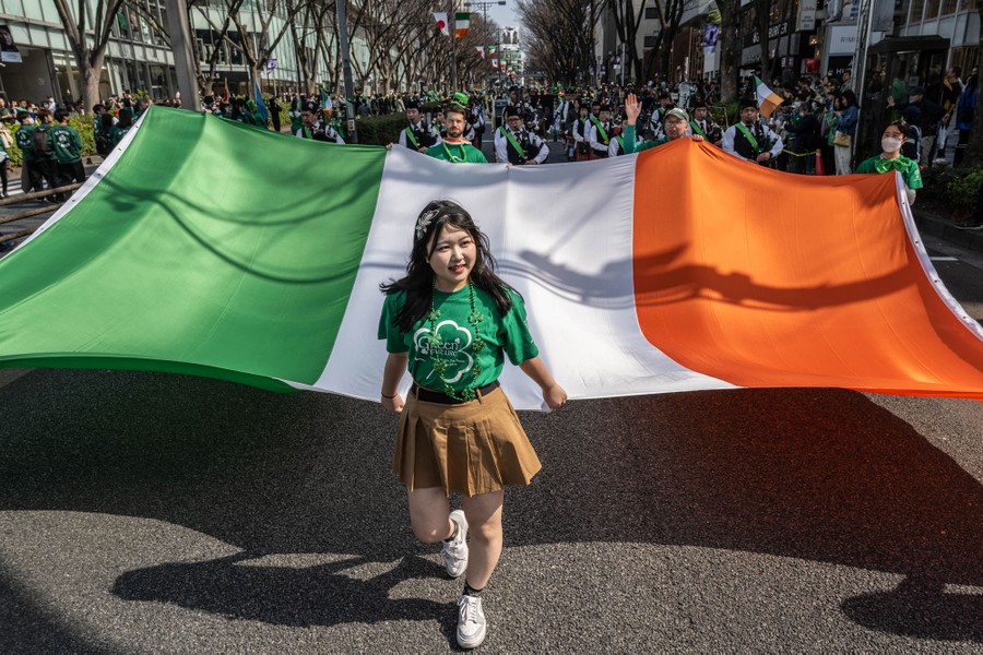 People carrying a large Irish flag take part in a St. Patrick's Day parade.