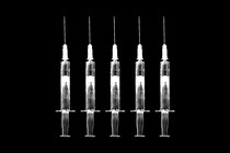 Graphic illustration of five white upright syringes in a line, on a black background.