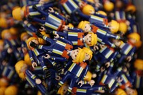 A sea of Playmobil figurines dressed in navy blue suits fills the frame.