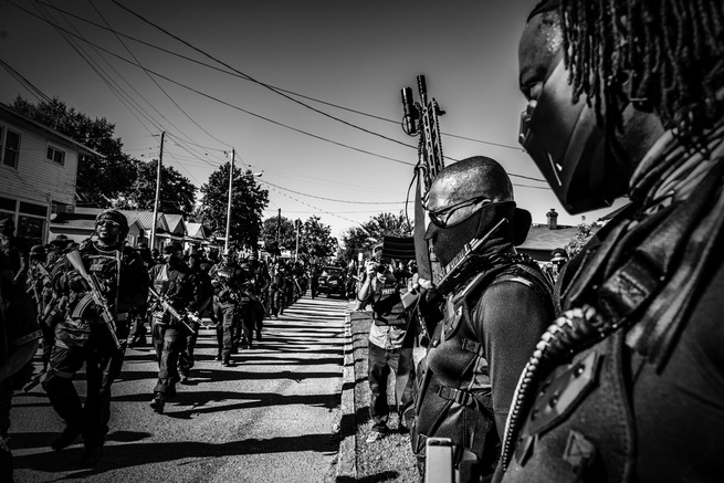 people lined up in rows with guns on a street