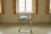 a baby in a hospital bassinet in a room