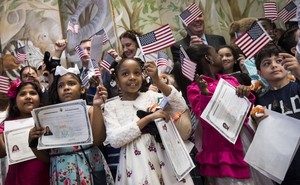 Children waving American flags and holding citizenship certificates