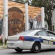 A Baltimore Police car passes a mural of Freddie Gray.