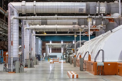 inside a nuclear plant in california, a series of three large silver pipes bend at right angles