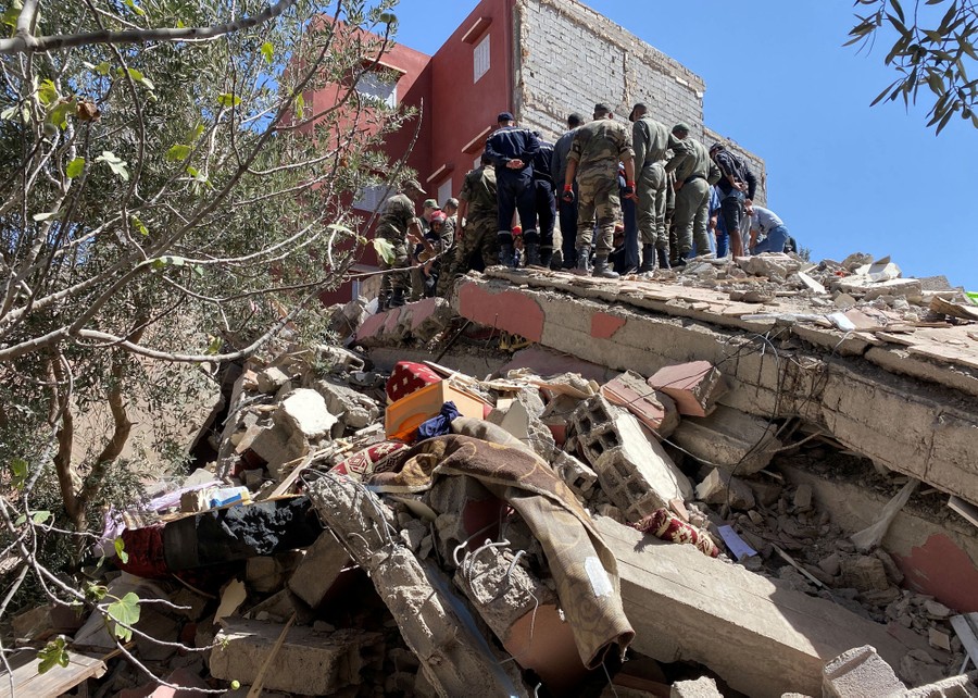 Rescue workers gather atop a collapsed building.