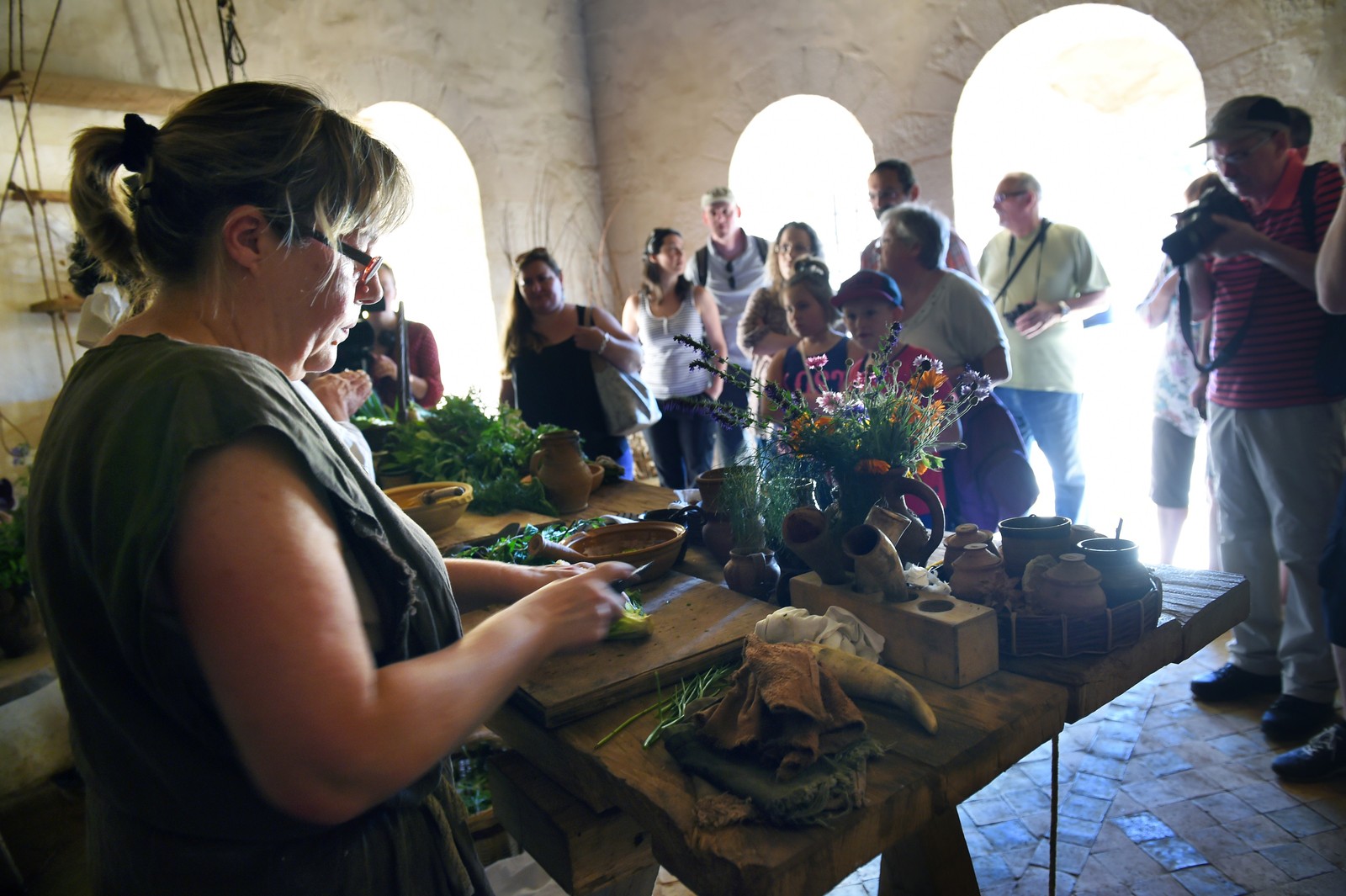 A person prepares a medieval dish for tourists visiting the construction site of Guédelon Castle.