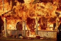 A house is seen completely engulfed in flames.