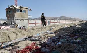 A Taliban fighter stands guard at the site of the August 26 twin suicide bombs