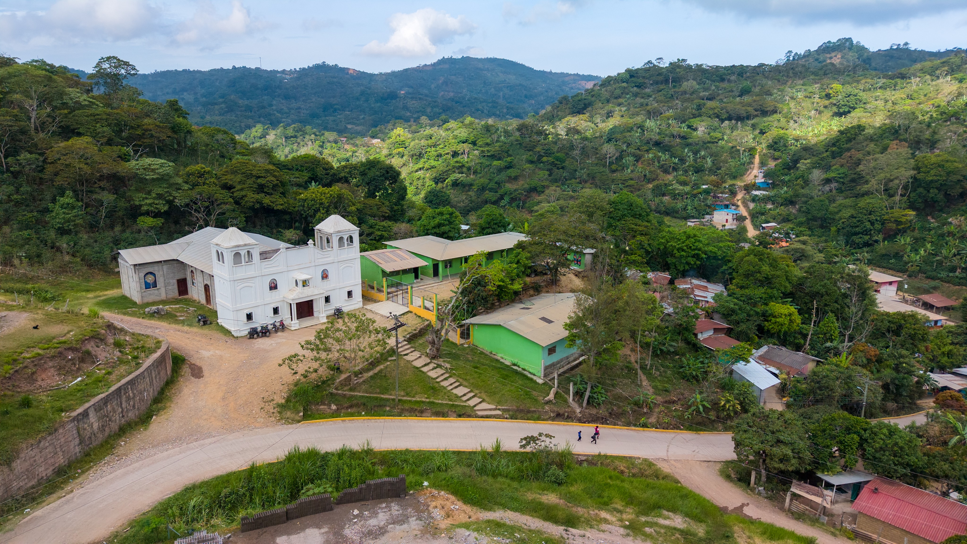 An aerial view of a Catholic church in a hillside Honduran village