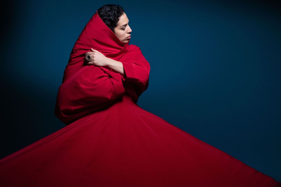 A dancer poses in a red dress.