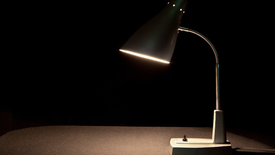 A lamp on a desk against a dark background