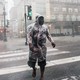 A person crosses a street in New Orleans under heavy rainfall during Hurricane Ida.