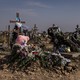 Rows of crosses for the Ukrainian victims of a Russian bomb attack. One cross has an image of a girl and a pink teddy bear underneath.