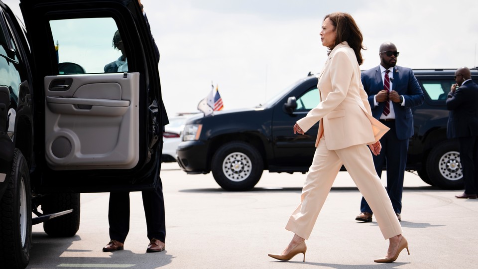 Kamala Harris striding toward an open car door