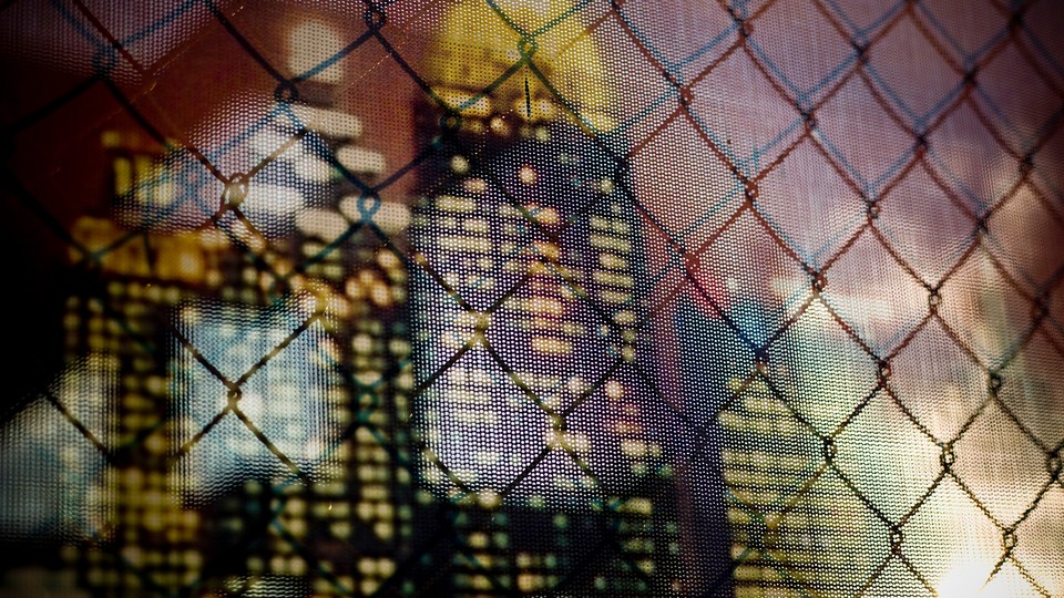 A skyline seen through a chain-link fence
