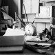 A black-and-white photo of a desk covered in personal effects