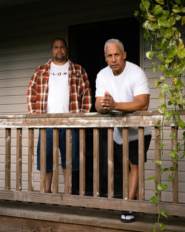 two men stand on a porch