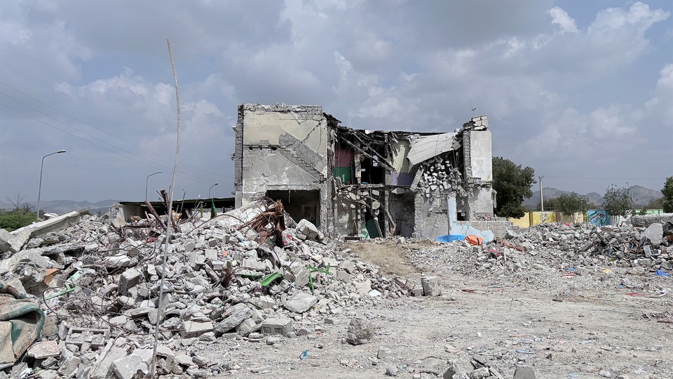 Photo of a destroyed building surrounded by rubble