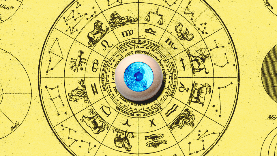 A blue artificial eyeball sits in the middle of a circular astrological chart.