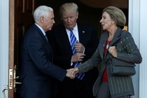 Vice President-elect Mike Pence shakes Education Secretary Appointee Betsy DeVos's hand. President-elect Donald Trump stand between them.