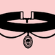A black choker necklace on a pink background