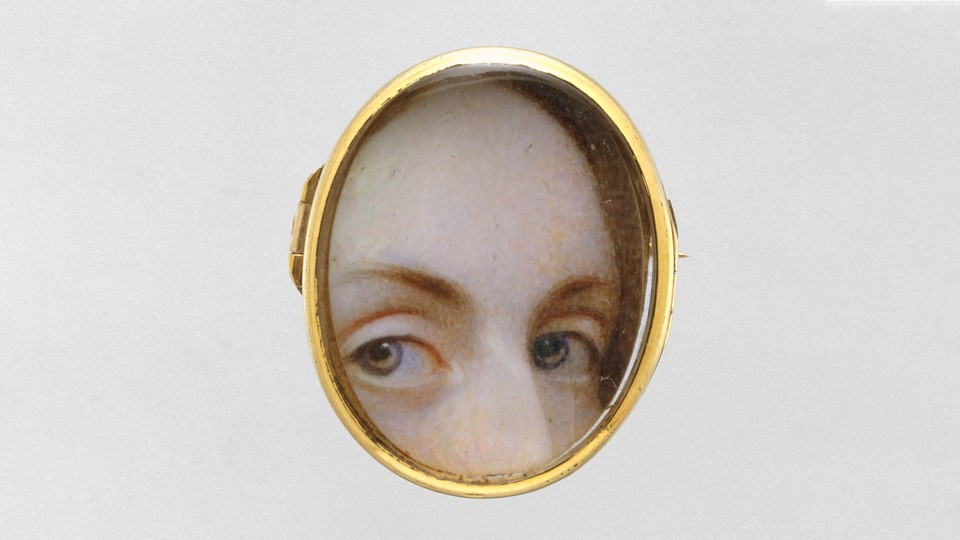 Part of a woman's face looking captured in a locket