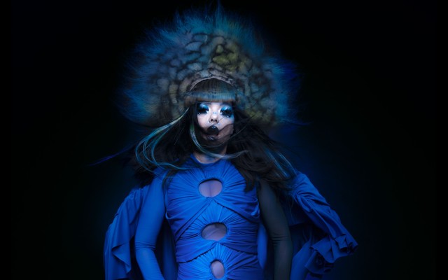 Björk in a blue gown with a large headdress