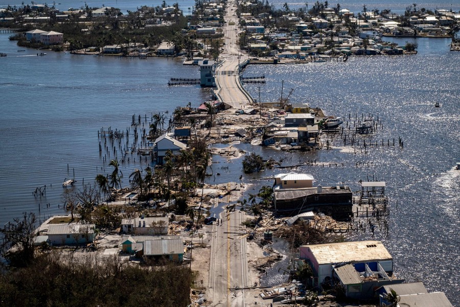An aerial view of storm-damaged island neighborhoods and a destroyed causeway