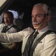 Nathan Fielder wears a white wig and fake mustache, posing as an airline pilot