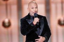 Jo Koy holding a microphone