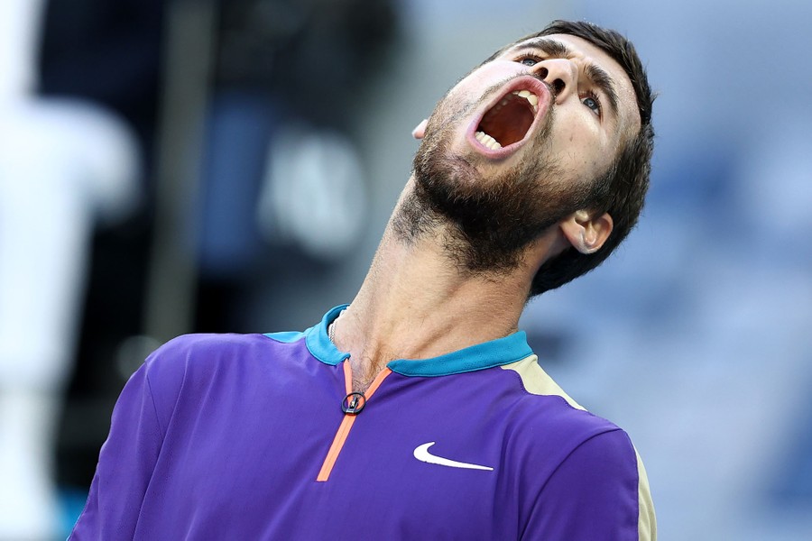Karen Khachanov leans back while shouting.