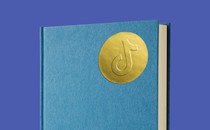 A book with a golden sticker showing TikTok's logo on the front