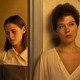 Kristen Stewart and Léa Seydoux standing solemnly by a doorway in "Crimes of the Future"
