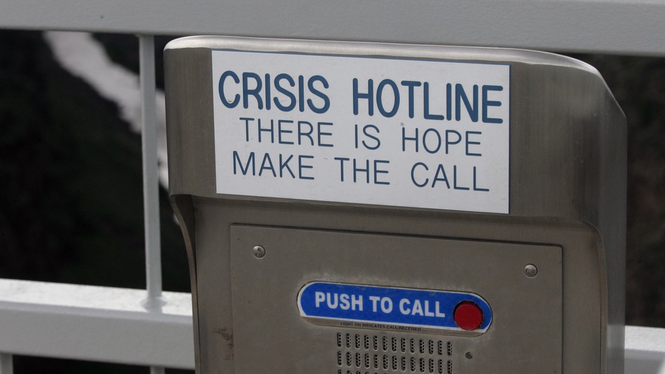 A metal box with a red button that says "push to call," and a placard reading "Crisis Hotline. There is hope make the call"