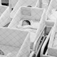Newborn babies in a hospital, but they're behind a wire fence