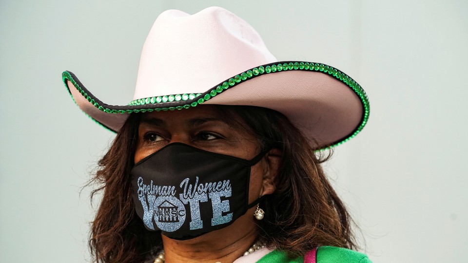A woman wearing a mask that says "Vote"