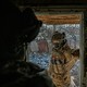 A Ukrainian soldier stands in a doorway