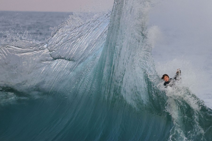 A young surfer is caught up in a spectacular wave.