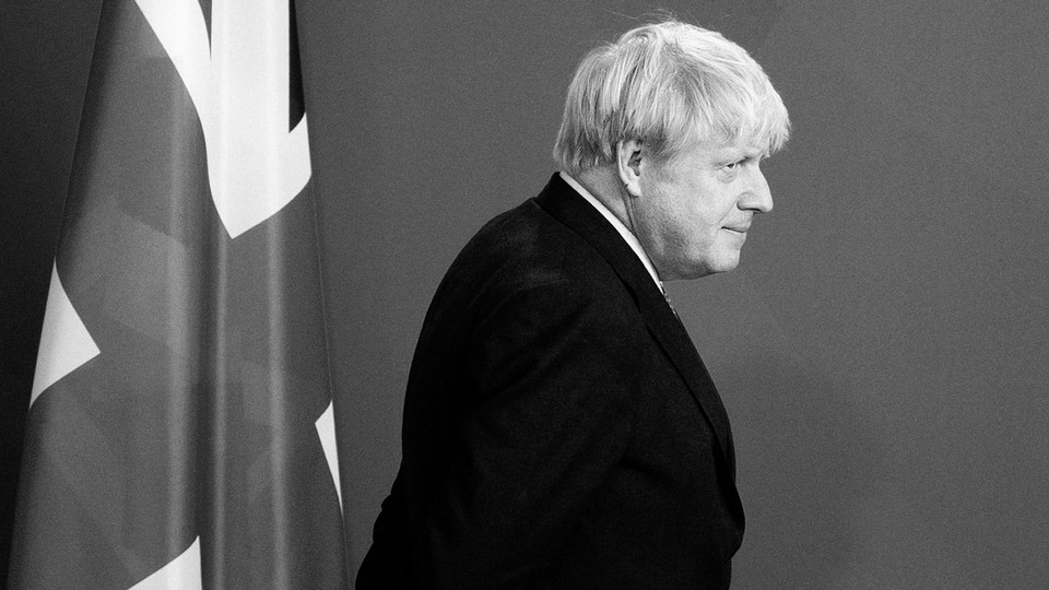 Boris Johnson walks past a British flag.