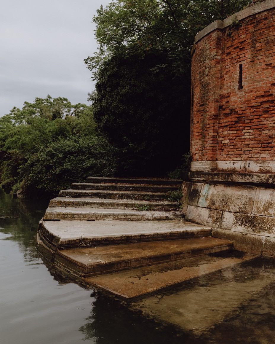 A red brick building with steps leading into the water at high tide