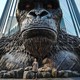 A child poses in front of a giant King Kong statue.