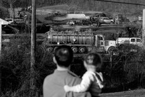 A family looks at the wreck in East Palestine.