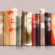 photos of contributors to the Oxford English Dictionary on a row of book spines