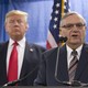 Joe Arpaio speaks with President Trump behind him.