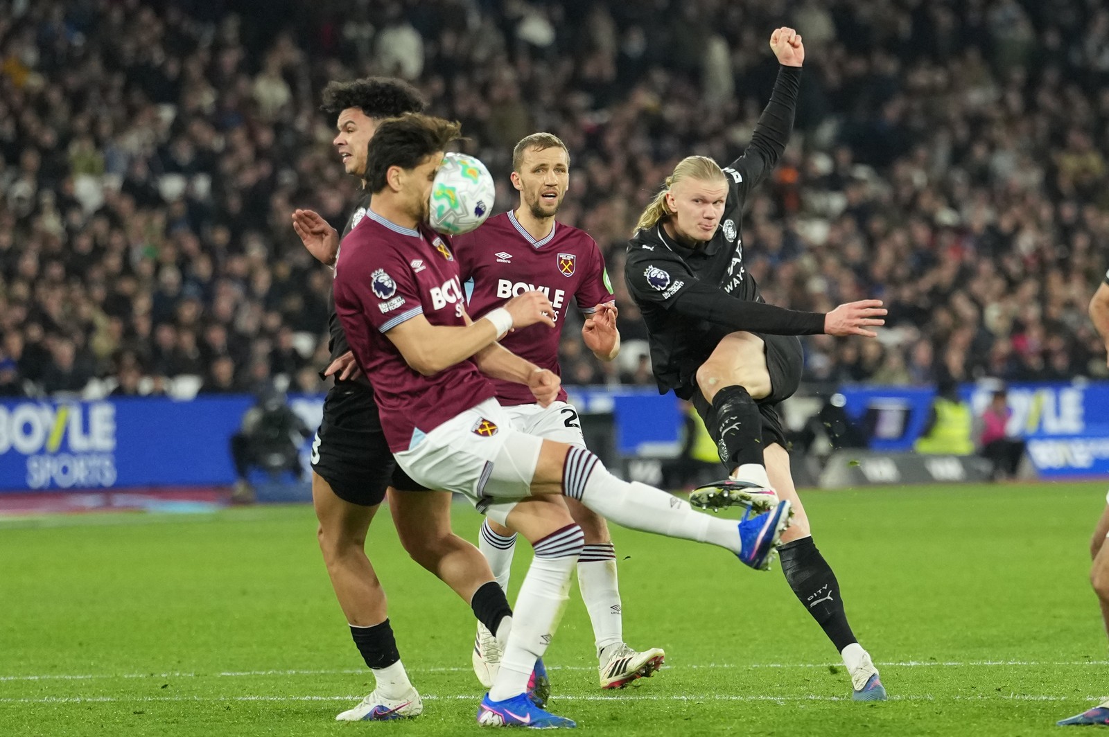 A soccer player takes a kicked ball in the face during a match.