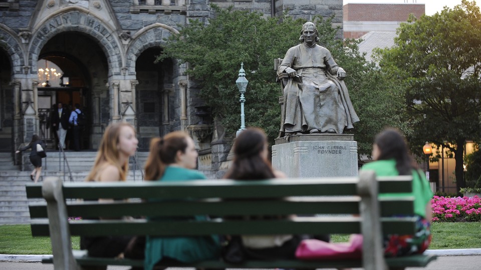 Students sit on a bench near Georgetown University's main lawn.