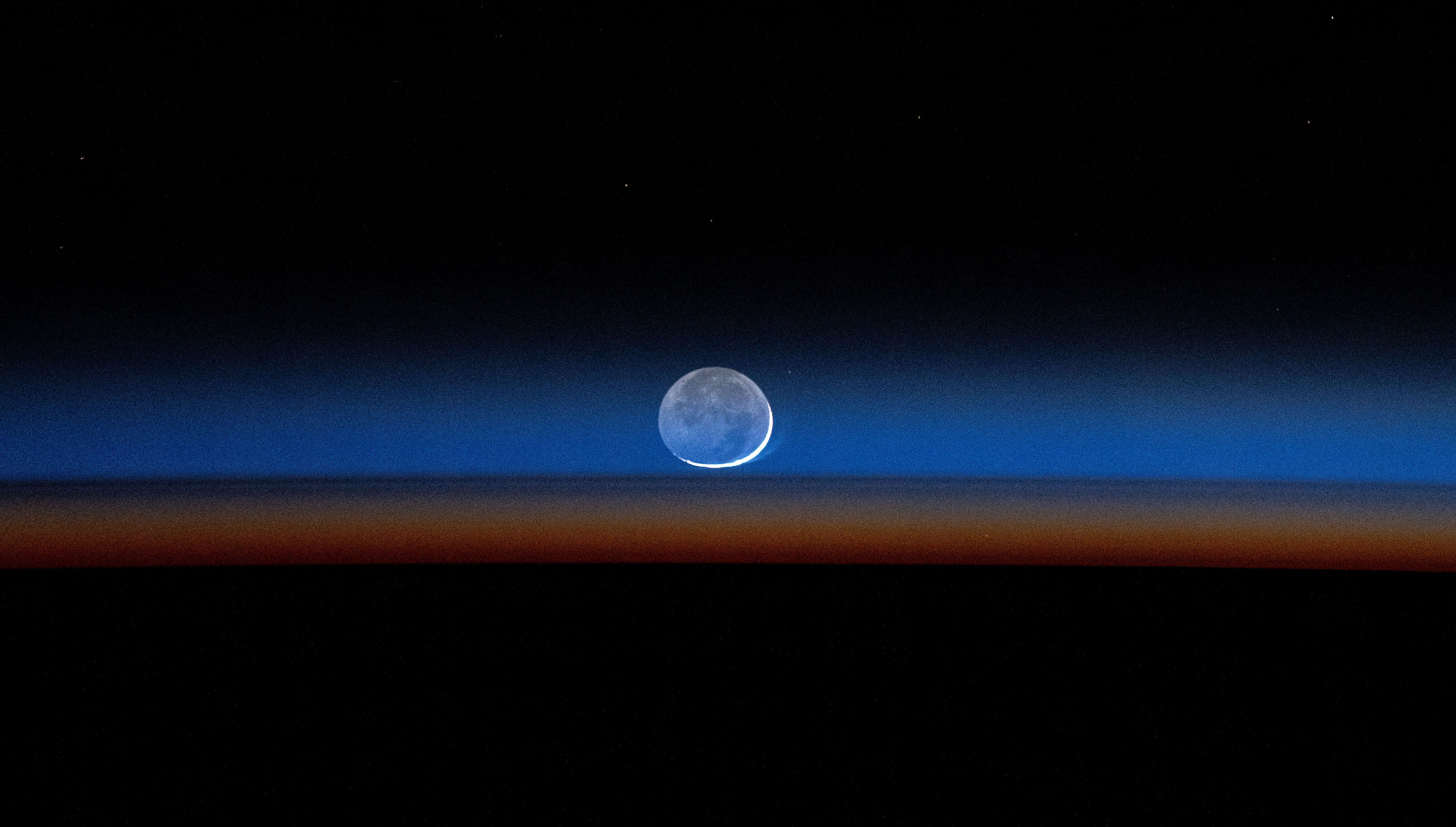 A new moon, seen near the Earth's horizon.